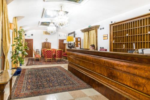 a woman sitting at a bar in a room at Charles Bridge Palace in Prague