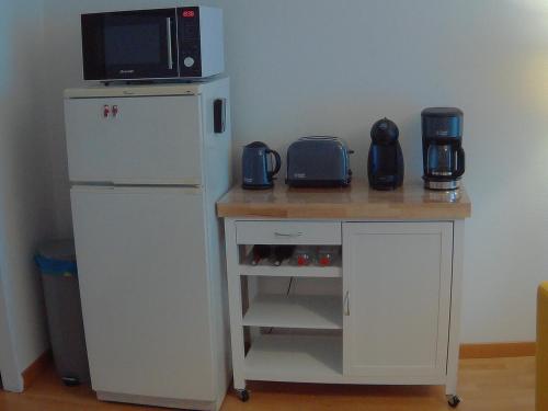 Elle comprend une petite table, un four micro-ondes et un réfrigérateur. dans l'établissement Allées d'Etigny T1Bis 41 m2 1 chambre 4 couchages 200 m de la Crémaillère Express 400 m des Thermes, à Luchon