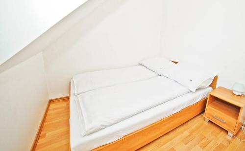 ソポトにあるGrand Apartments - Timber Apartment in Sopotのウッドフロアの客室の白いベッド1台