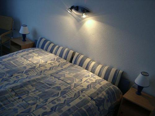 シュレースヴィヒにあるFerienwohnung-im-Wikingturmのベッドルーム1室(ベッド1台付)、壁に照明が備わります。