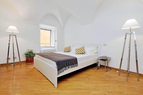 1 dormitorio blanco con 1 cama y 2 lámparas en Clementina Charme - My Extra Home, en Roma