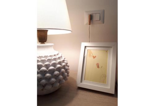 a lamp and a picture next to a vase on a table at Ai Sottani B&B Deluxe Suite in Gioia del Colle