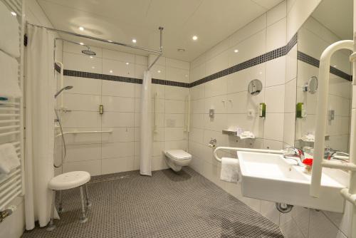 a bathroom with a sink and a toilet and a shower at Aribo Hotel in Erbendorf