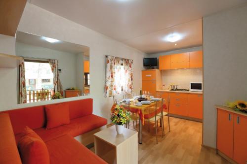 a living room with a red couch and a table at Village Camping Joker in Cavallino-Treporti