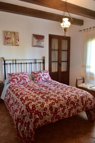 エル・ガストルにあるCasa Rural Las Adelfasのベッドルーム1室(赤い掛け布団付きのベッド1台付)