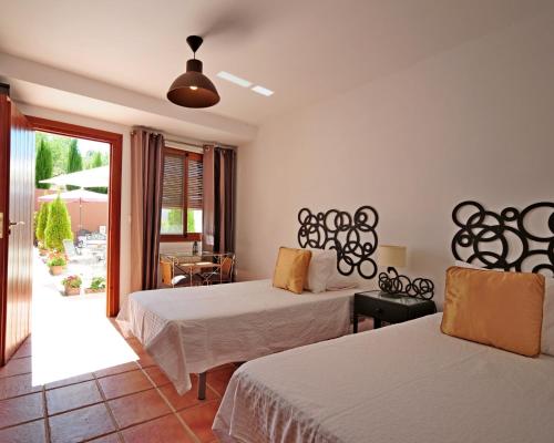 a hotel room with two beds and a balcony at La Fuente Retreat in Lecrin
