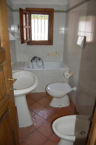 a bathroom with a toilet and a sink and a tub at Dhora in Cavo
