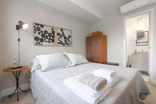 Un dormitorio con una cama blanca con toallas. en Estúdio no Add Nova Berrini - 512, en São Paulo