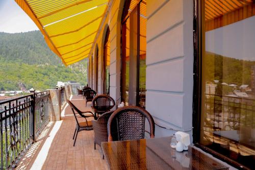 a balcony with tables and chairs on a building at Borjomi Palace Health & Spa Center in Borjomi