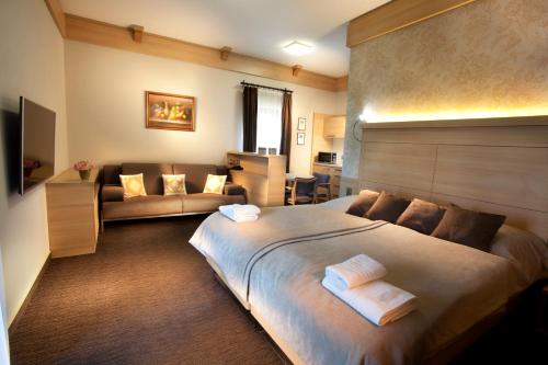 a bedroom with a large bed and a couch at Vinařský penzion André in Velké Pavlovice