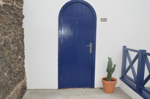 een blauwe deur met een cactus ervoor bij Casa Cabrera - 2 apartamentos con vistas al mar in Caleta de Caballo