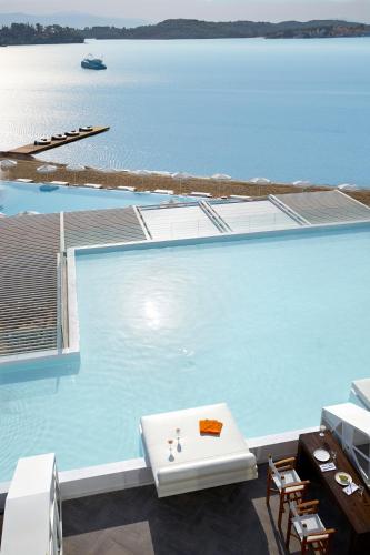 a swimming pool with a view of the water at Nikki Beach Resort & Spa Porto Heli in Porto Heli