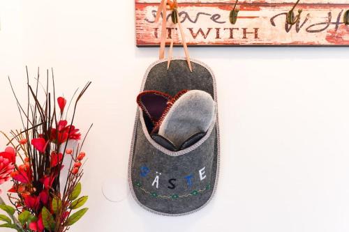 a felt shoe hanging on a wall next to flowers at VIVA RIVA ZADAR in Zadar