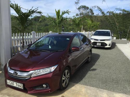 a red car parked next to a white fence at Hotel Mount Castle in Hatton