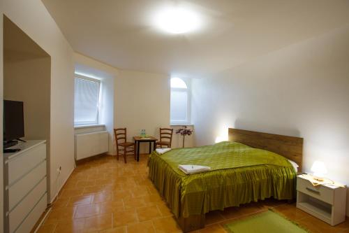 een slaapkamer met een bed en een tafel en stoelen bij Penzión Žemberovce in Dolné Žemberovce