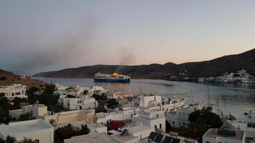 a boat in a body of water with buildings at Pension The Big Blue in Katapola