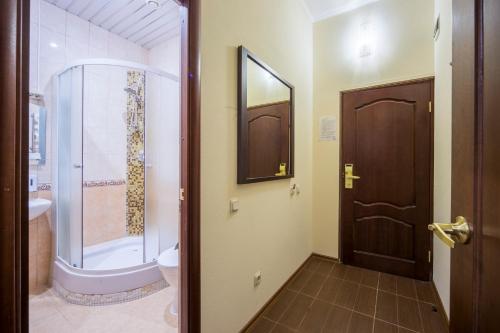 a bathroom with a shower and a toilet and a door at Hotel Graf Tolstoy in Saint Petersburg