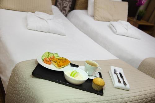 a tray of food on a bed in a hotel room at Hotel Graf Tolstoy in Saint Petersburg