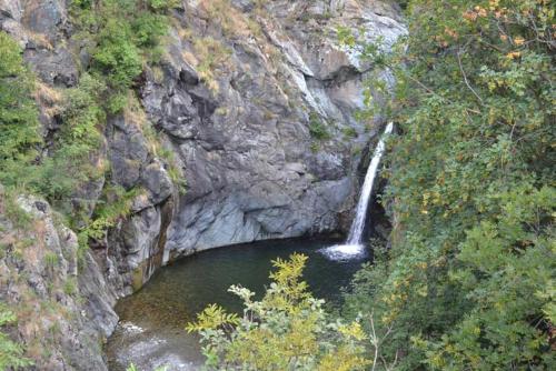 a waterfall on a mountain with a pool of water at Casa Acquarossa in Rubiana