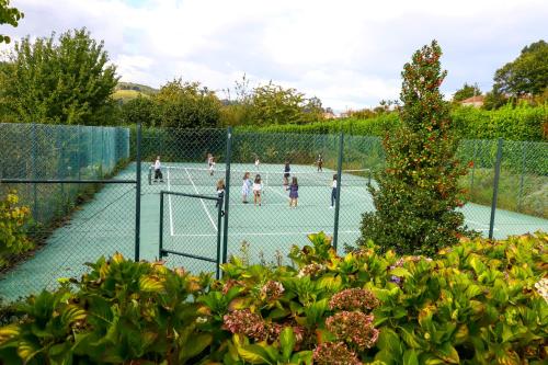 a group of children playing tennis on a tennis court at Casa De Carcavelos in Cabeceiras de Basto