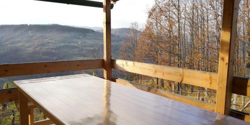 a table on a porch with a view of the mountains at Koliba Pčelica 1-SPA in Bijelo Polje