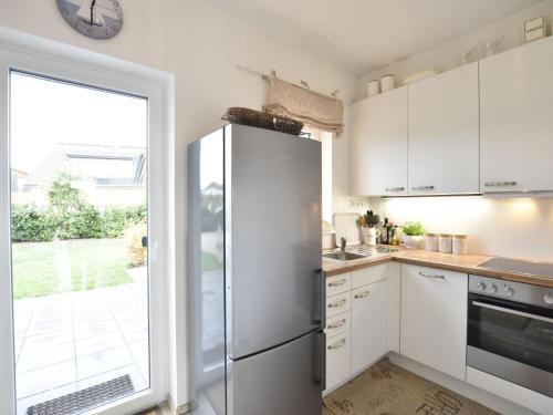 a kitchen with white cabinets and a refrigerator at Baltic Hus Zierow s Gem in Zierow