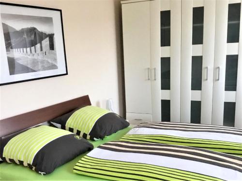1 dormitorio con 2 camas con rayas verdes y blancas en Ferienwohnung Alexander Feiss, en Schonach