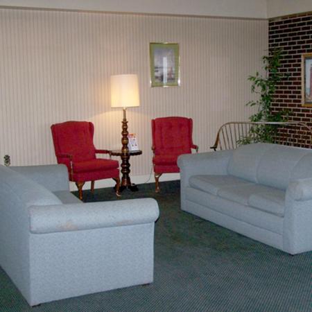 sala de estar con sofá y 2 sillas rojas en Harbor Inn, en Philipsburg