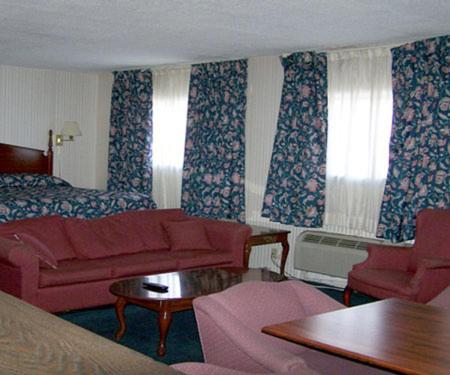 a hotel room with a couch and a bed at Harbor Inn in Philipsburg