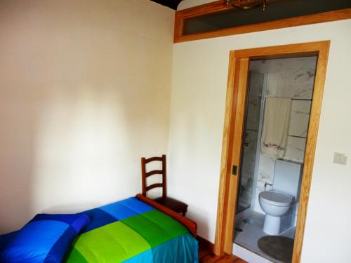 a bedroom with a bed and a bathroom with a toilet at Casa da Granja in Arouca