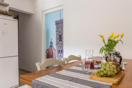una mesa de comedor con un plato de uvas. en Emma & Olga Apartments -In the city Centre-, en Florencia