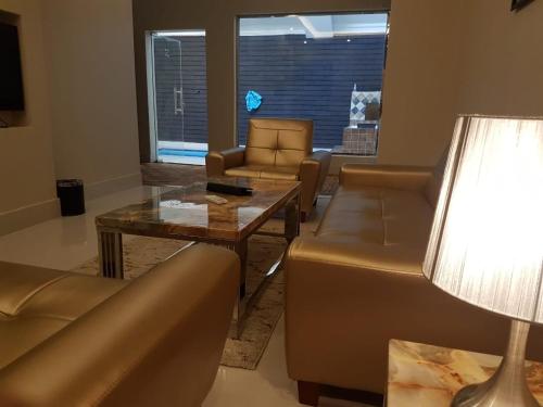 een woonkamer met banken en een tafel en een lamp bij Durat Al Lith Chalet in Al Lith