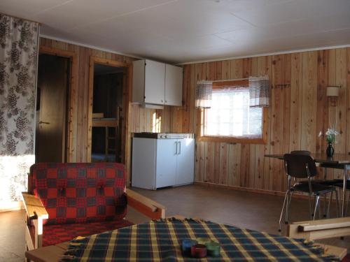 a living room with a refrigerator and a table and chairs at Visit Wilderness in Åmli