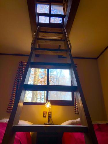 a bedroom with a ladder leading to a window at The Guest House Japan Hakuba in Hakuba