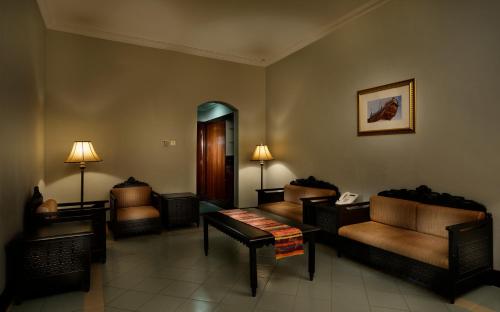 a living room with couches and chairs and a mirror at Masira Island Resort in Ḩilf