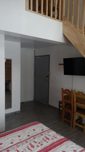 a bedroom with a bed and a staircase and a door at Hotel Restaurant LE YETI in Les Rousses