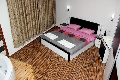 a bedroom with a bed and a rug at Hotel Albatros in Prizren