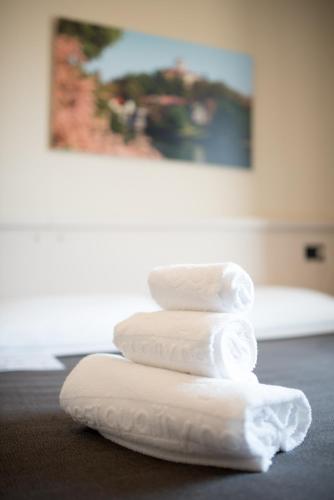 three towels stacked on top of each other on a table at Green Class Hotel Candiolo in Candiolo