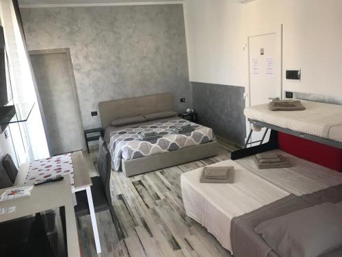 mały pokój z 2 łóżkami i 2 stołami w obiekcie B&B ATTICO GALLIERA w Bolonii