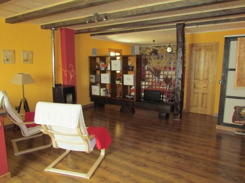 uma sala de estar com duas cadeiras brancas e uma mesa em CASA RURAL El Refugio del Poeta em Triufé