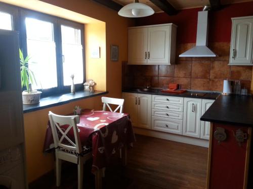 a kitchen with a table and chairs in a room at CASA RURAL El Refugio del Poeta in Triufé