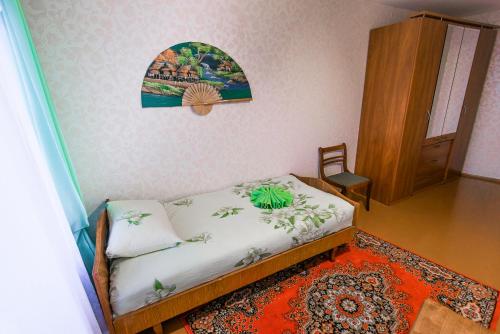 a small bedroom with a bed and a wooden cabinet at Большая квартира на пр. МИРА in Salihorsk
