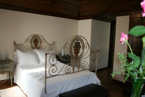a bedroom with a metal bed with white pillows at Casa De Carcavelos in Cabeceiras de Basto