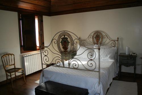 a bedroom with a white bed with a metal frame at Casa De Carcavelos in Cabeceiras de Basto
