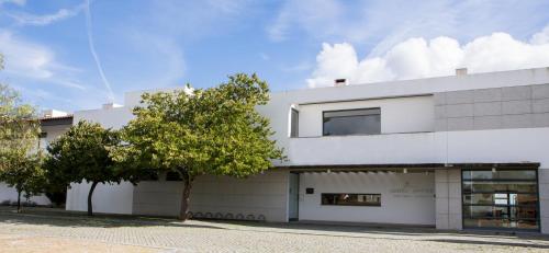 a white building with a tree in front of it at Hotel Rural Santo Antonio in Arronches