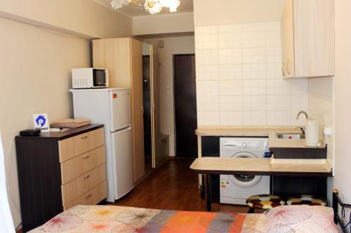 a small kitchen with a sink and a refrigerator at Apartments Zhambyl 159 in Almaty