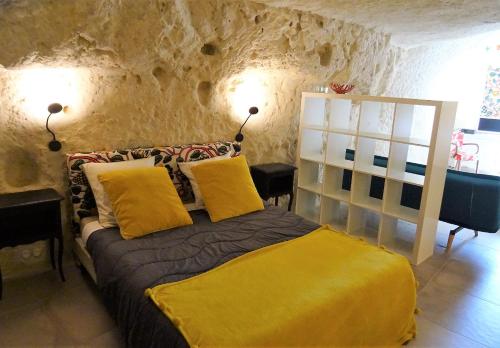 1 dormitorio con 1 cama con almohadas amarillas en Gite de Loup-Terre en Tours
