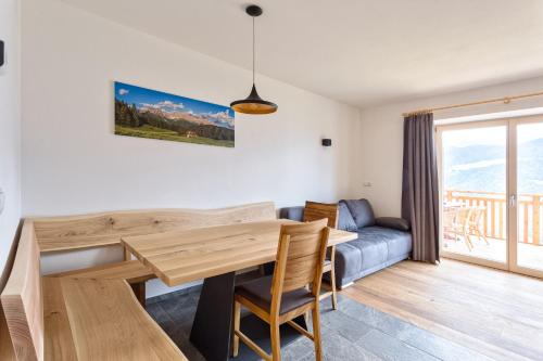 a dining room with a wooden table and a couch at Frühaufhof in Barbiano