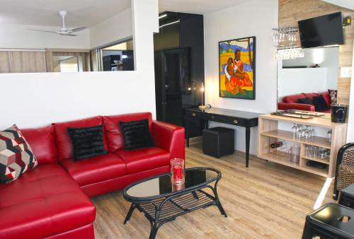 salon z czerwoną kanapą i stołem w obiekcie 205 New Cumberland w Kapsztadzie