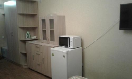 a small kitchen with a microwave on top of a refrigerator at Apartments Zhambyl 159 in Almaty